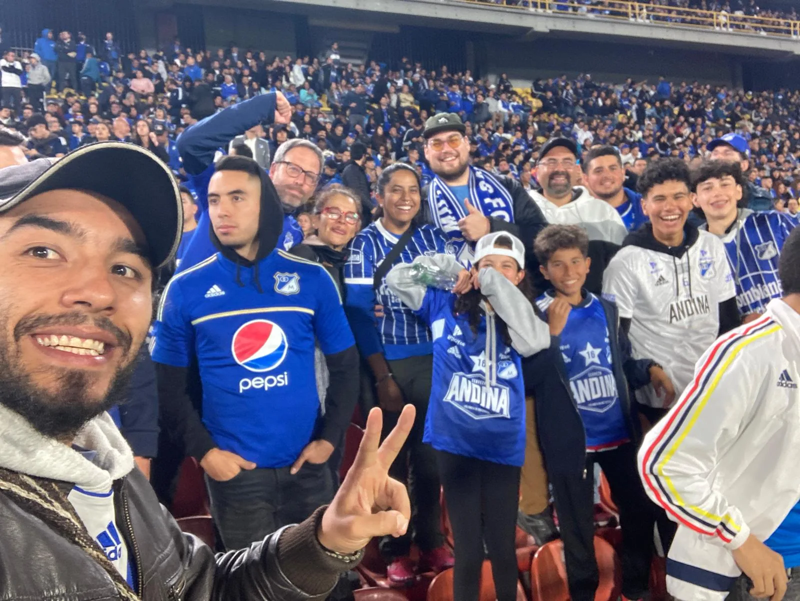 Travelers cheering at a live Colombian soccer match in El Campín Stadium, Bogotá — part of The True Colombian Football & Soccer Experience tour.