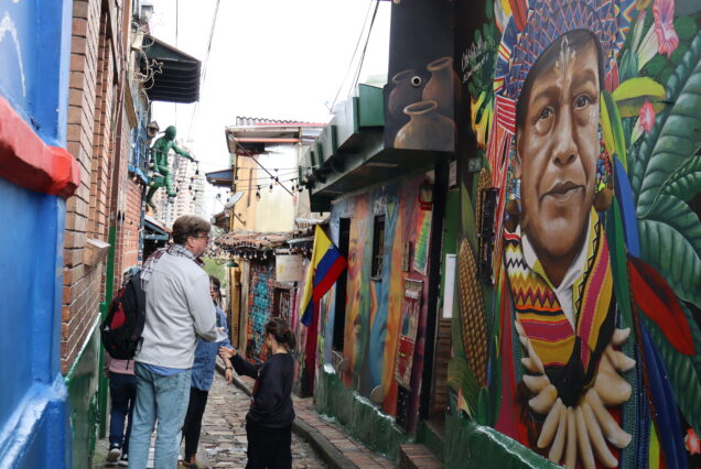 Viajeros mirando el arte callejero en una parada del tour en Bogota