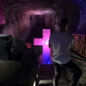 Tourist admiring an illuminated cross inside the Zipaquirá Salt Cathedral during the express tour from Bogotá